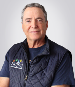 A photo of Gene Siegel wearing an NCJFCJ vest
