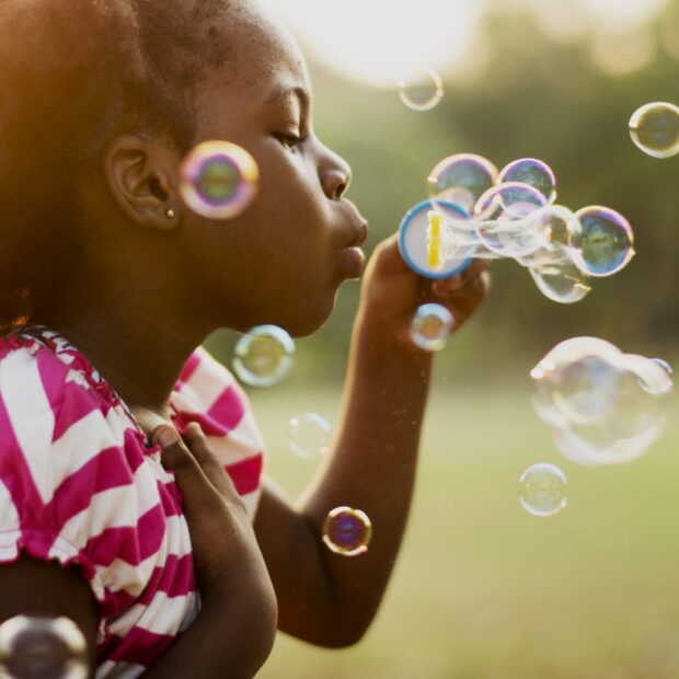 Children is playing bubbles in a park