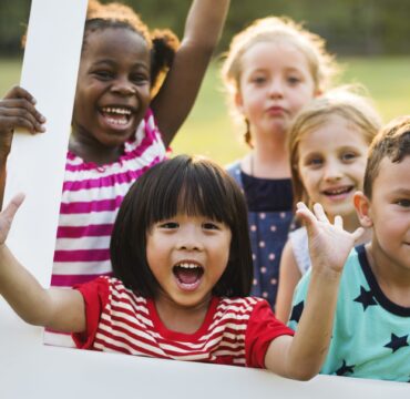 Group of kindergarten kids friends playing playground fun and smiling