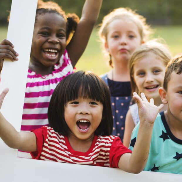 Group of kindergarten kids friends playing playground fun and smiling